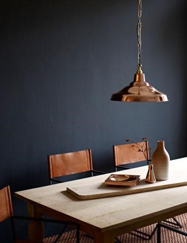 Bronze suspension lamp and decorations on the table, great combination with the dark wall