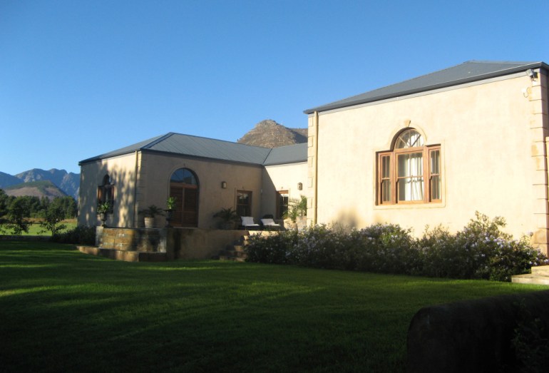 Back of the house, with the lawn sloping toward the river