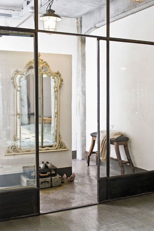Contrast is everything: delicate gold mirror in old industrial building. Love the cement texture on the floor too - via Greige Design