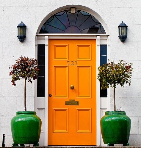 Orange front door - via House and Home